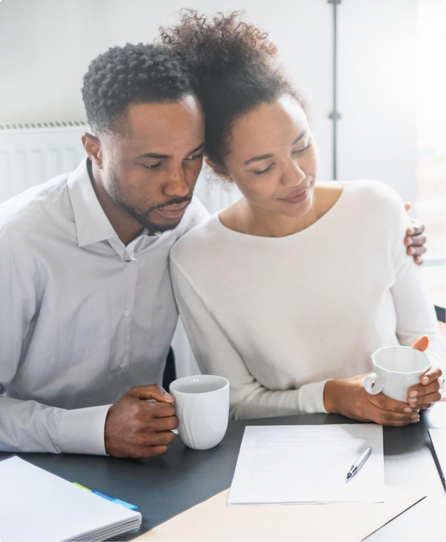 Calm couple with coffee mugs analyzing a legal document.